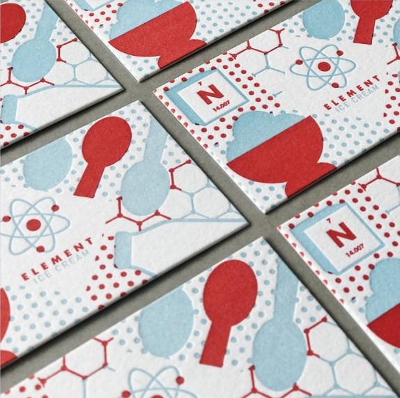 Colourful letterpress printed cards with atom and molecule illustration pattern in red and light blue.